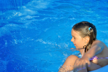 Real toddler girl relaxing at swimming pool