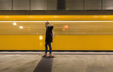 junges Mädchen vor abfahrendem Zug der U-Bahn in Berlin © spuno