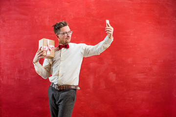 Young beautiful man with gift and phone