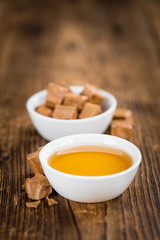 Caramel Sirup (selective focus) on vintage wooden background