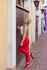 Portrait of a beautiful blonde in red pants