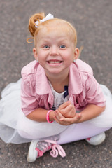 A cute little girl in a beautiful dress and sneakers playing on