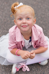 A cute little girl in a beautiful dress and sneakers playing on