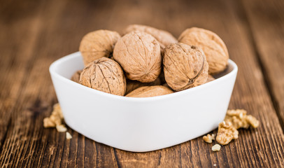 Whole Walnuts on wooden background (selective focus)