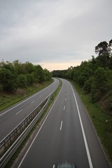 Fototapeta premium Autobahn Straße road empty Germany sky nature trees forest cars drive clouds