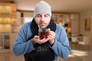 Sick man holding a warm cup of tea