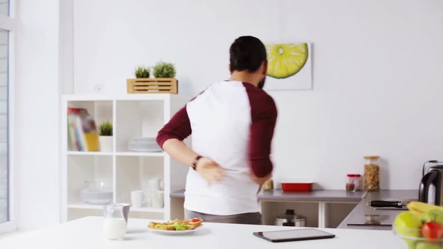 man eating breakfast and dancing at home