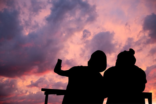 Silhouettes a Young Women and Men Selfie
