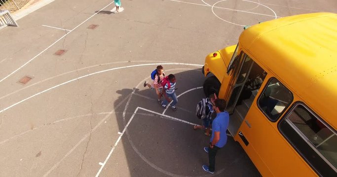 Teacher giving high to kids while entering in bus