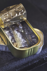 Sardines in a can on black rustic background