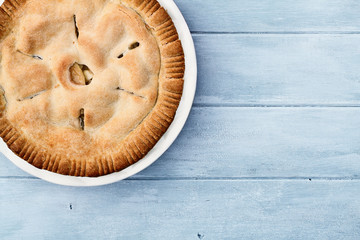 Obraz na płótnie Canvas Apple Pie Over Blue Wooden Table Top