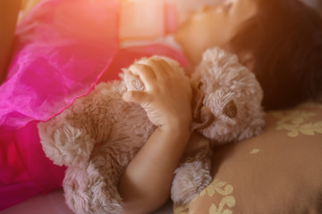 happy little girl in cap playing with Teddy bear in summer Park