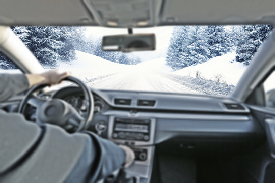 car interior with driver and winter road 