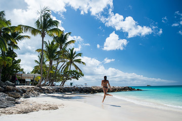 Fototapeta na wymiar Young woman running at the tropical beach