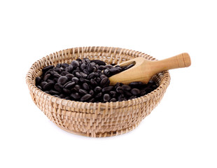 Fresh coffee beans in basket with wooden scoop  isolated on whit