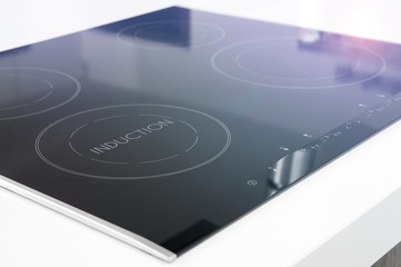 Modern black induction cooker on white countertop