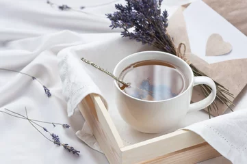 Rolgordijnen Thee Een dienblad met een kop hete thee en lavendel liefdesbrief in bed