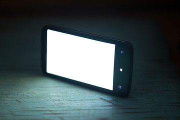 smartphone with white screen on a wooden background