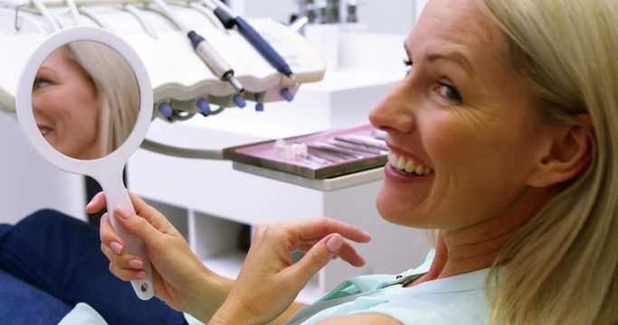 Patient checking her teeth in mirror