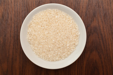 White plate with rice on wooden background