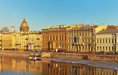 Obraz premium Saint Petersburg. English Embankment (Angliyskaya Naberezhnaya) of the Neva River and the dome of St. Isaac's Cathedral in the sunset light spring