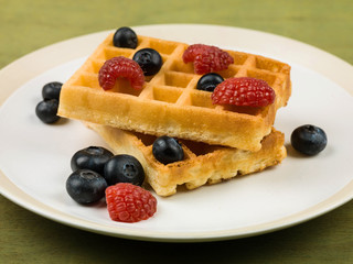 Obraz na płótnie Canvas Waffles With Fresh Raspberries and Blueberries