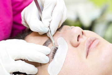 Woman on the procedure for eyelash extensions, eyelashes lamination