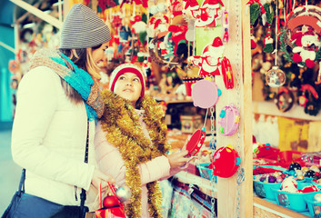 Glad woman with small daughter in market