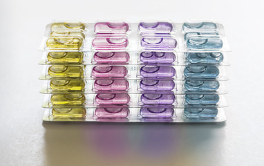 Colorful Capsule pills in packages use in pharmaceutical manufacturing, drug, medicine, garlic oil, fish liver oil.