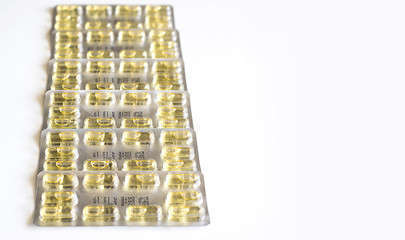 Yellow Capsule pills and package use in pharmaceutical manufacturing, drug, medicine, garlic oil, fish liver oil.