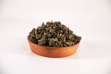 The natural dried tea leaves on wooden bowl.