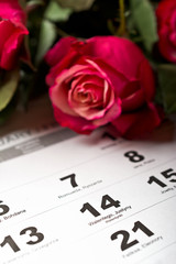 Calendar page with the red hearts and bouquet of red roses on February 14 of Saint Valentines day.