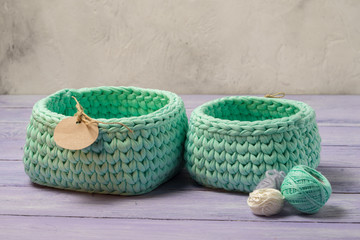 Two knitted empty baskets, with a blank circular paper label. copy space above.