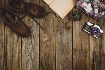 Accessories for travel top view on wooden background with copy space. Adventure and wanderlust concept image with travel accessories. Preparing for an exotic trip, journey and sightseeing.
