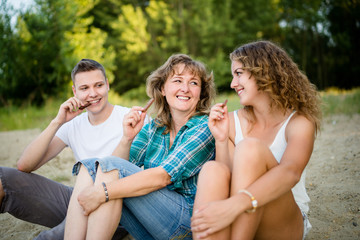 Smiling family of three enjoying chocolate bar