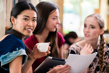 Young woman showing paperwork to her friends