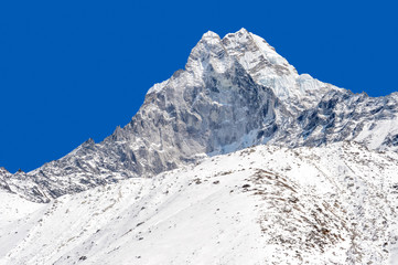 Snowy peak over blue sky (Ama Dablam in the Everest Region)
