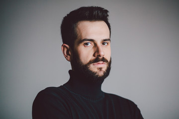 Obraz premium Portrait of a handsome bearded young man looking in camera