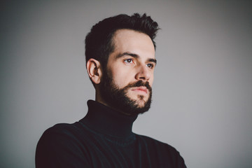 Portrait of a handsome bearded young man looking a side