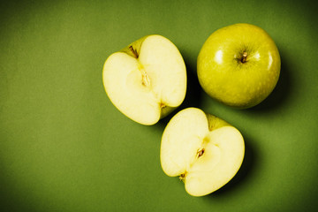Two fresh green apples on a colored background
