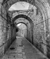 Narrow street in old city of Jerusalem, Israel. Image toned with B&W filter for retro style