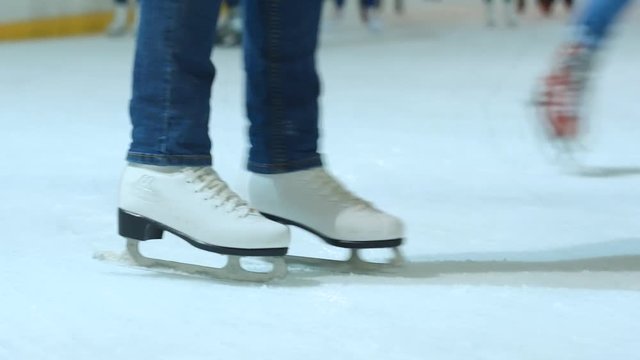 Young woman skating on ice with figure skates