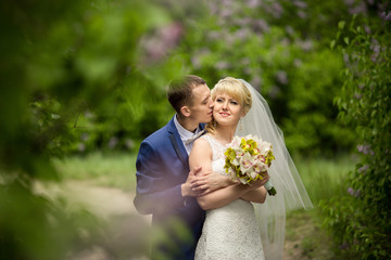 Wedding portrait of bride and groom in green park