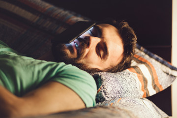 Young man using a smartphone in his bed at night