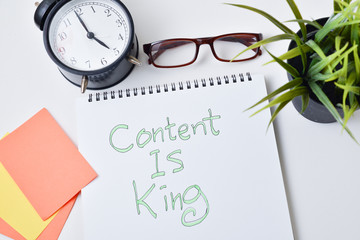  modern White office desk table with text  writing content is king on note book.Top view with copy space, flat lay.