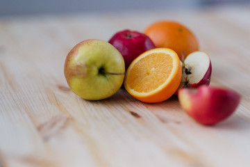 Fresh red and green apple, orange on wooden decks.