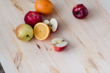 Fresh red and green apple, orange on wooden decks.
