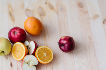 Fresh red and green apple, orange on wooden decks.