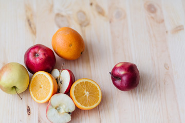 Fresh red and green apple, orange on wooden decks.