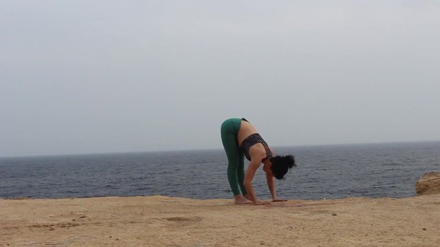 Chica practicando yoga en la playa